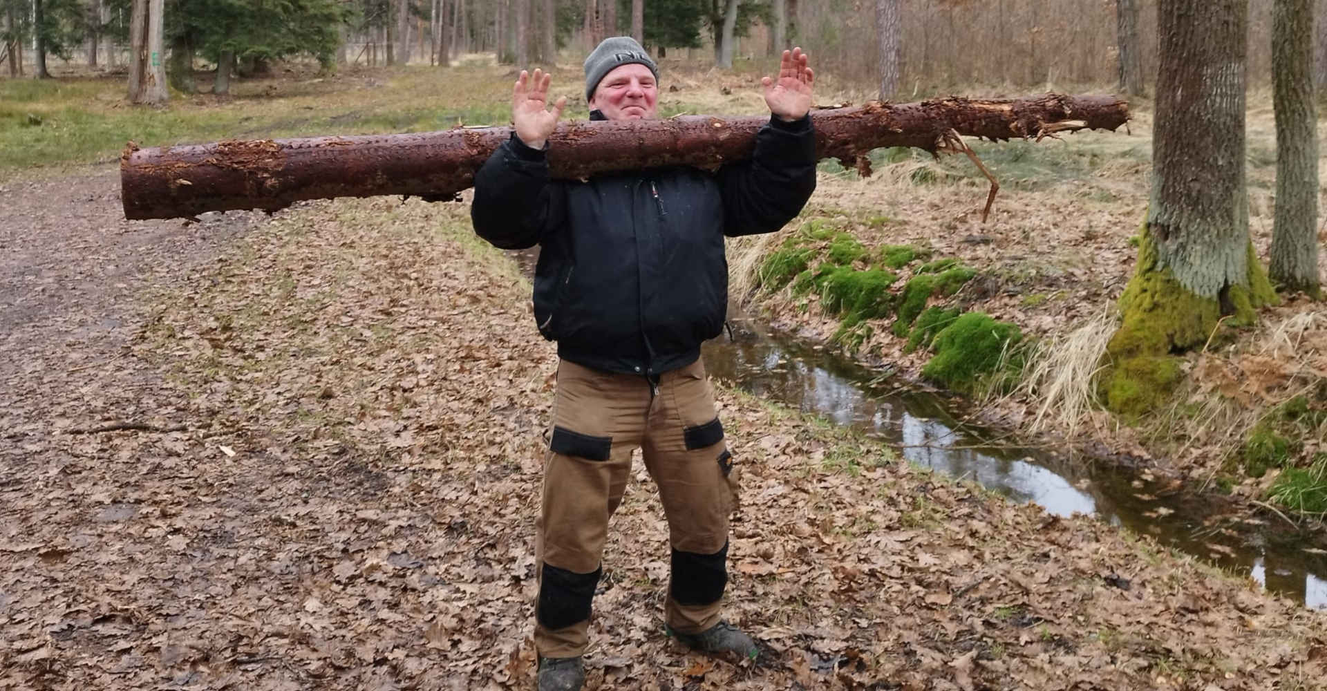 Mężczyzna z balem drewna